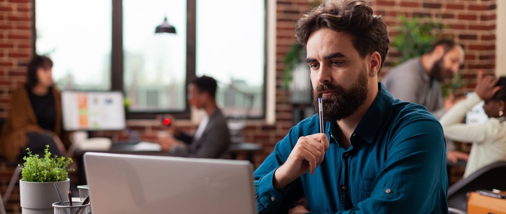 a man sitting at a desk with a laptop computer