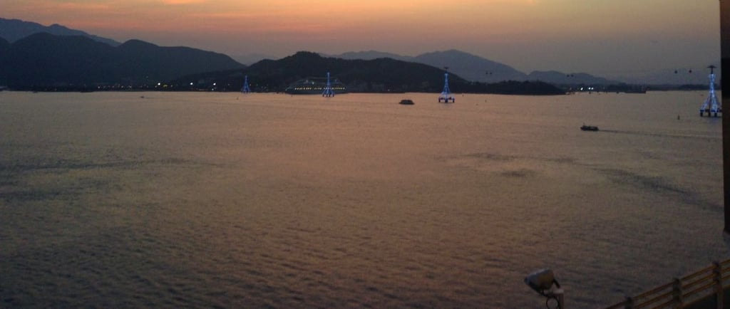 Navio chegando ao porto de Keelung pelo mar ao amanhecer, com vista da cidade e da costa