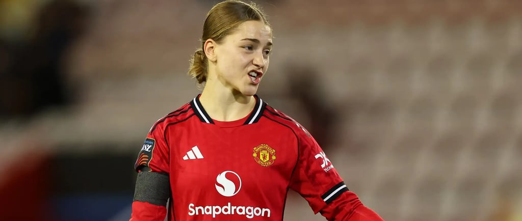 a woman in a red jersey shirt is holding a soccer ball