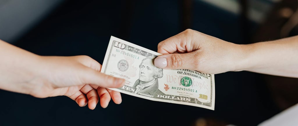 two people holding onto a dollar bill representing blog post about gold ira fees and a guide to understanding gold ira fees