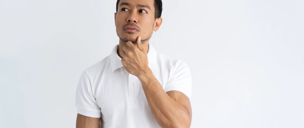 a man in a white shirt and jeans standing in front of a white wall