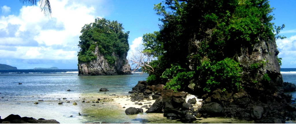Vista panorâmica do Fatu-ma-Futi, o icônico cartão-postal de Pago Pago, Samoa Americana, com o mar azul e penhascos verdes ao