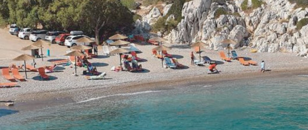 a beach with many chairs and umbrellas