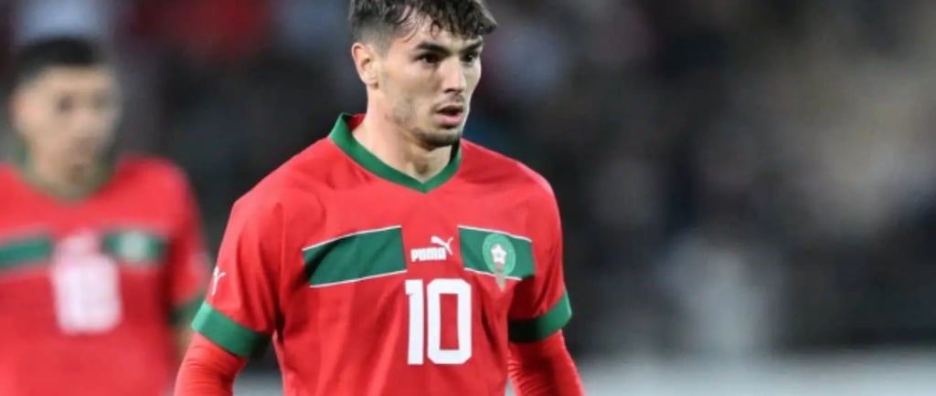 a soccer player in a red jersey and green pants