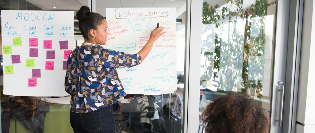 A woman presenting design artefacts to a group of stakeholders.jpg