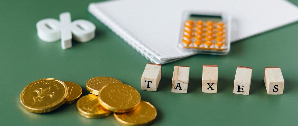 gold coins, calculator and word taxes show gold ira taxes and learning potential tax benefits