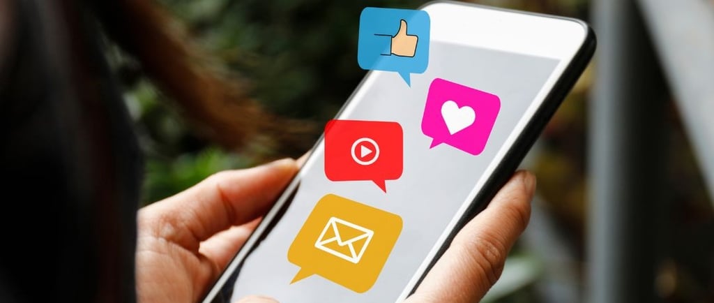 Uma pessoa segurando um celular com ícones de avisos