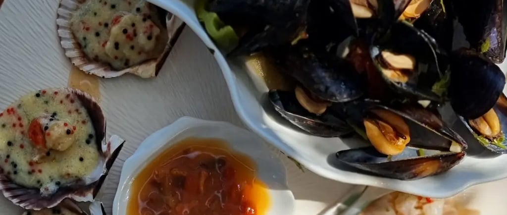 a plate of food with a bowl of food and a glass of wine