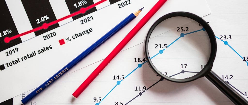 magnifying glass highlighting investing chart symbolizing gold market for precious metals