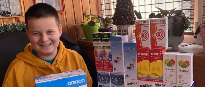 хлопчик тримає коробку з ліками