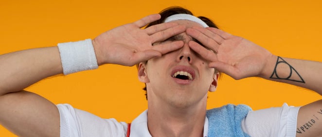 a man with a towel around his shoulder. He's tired an sweaty