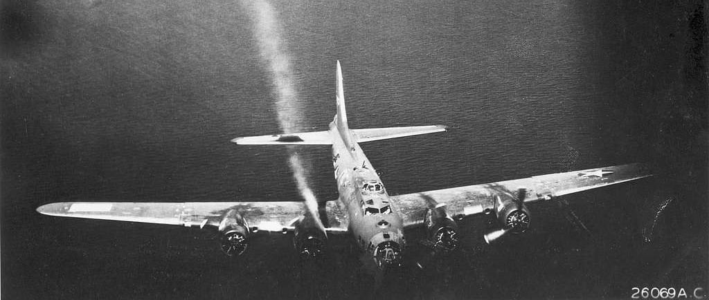 Battle damaged B-17 over water