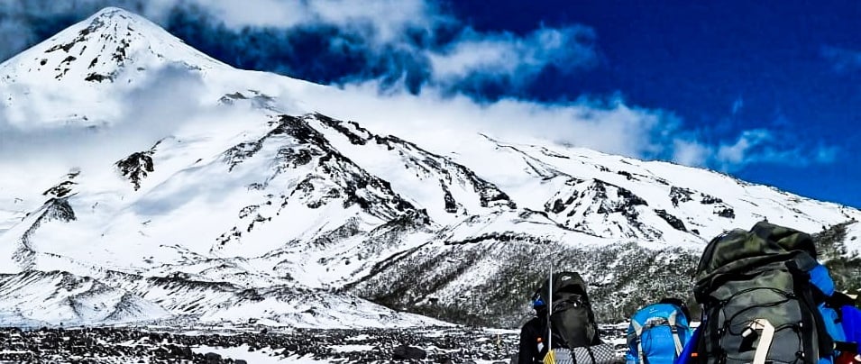 a group of people walking up a snowy mountain