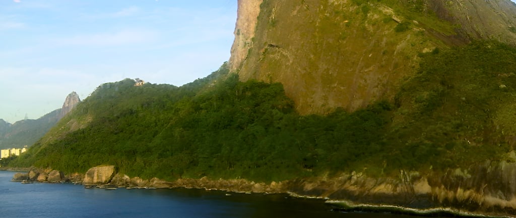 Navio de cruzeiro chegando ao Rio de Janeiro com o Pão de Açúcar ao fundo.