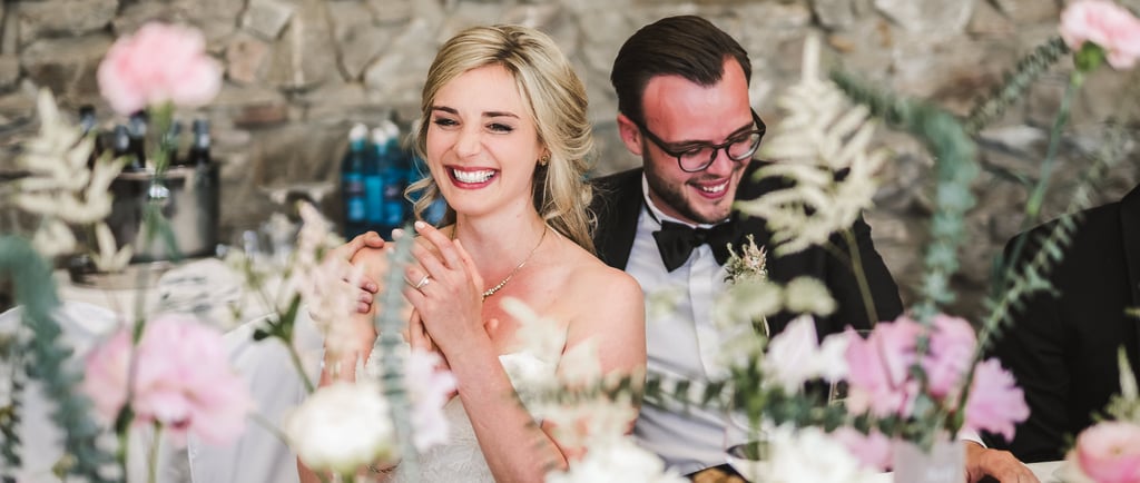 a man and woman sitting at a table with flowers