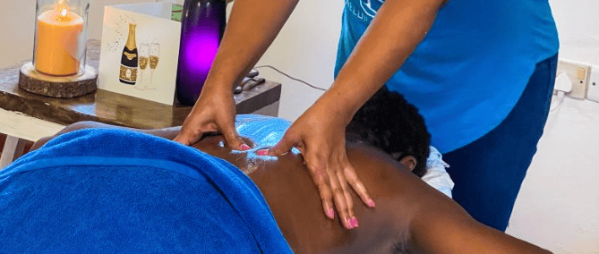 a woman in a blue shirt is getting a massage