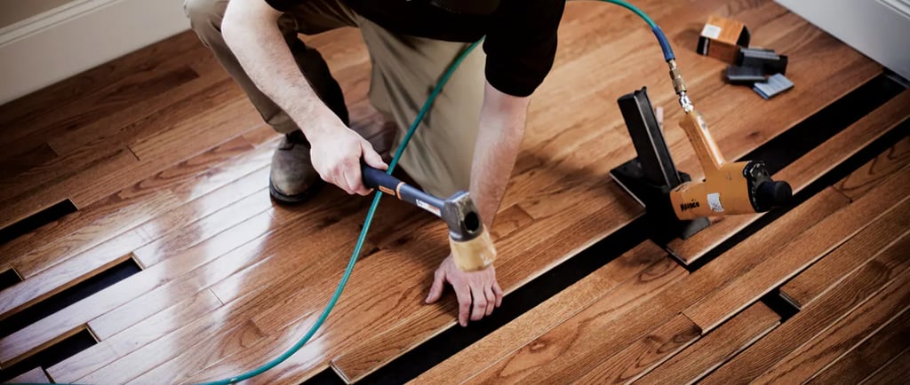 Hardwood floors installer installing prefinished hardwood using air nailer.
