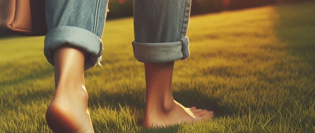 a person walking on a grassy field with a handbag
