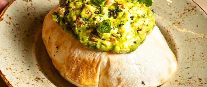 a person holding a plate with a bowl of food