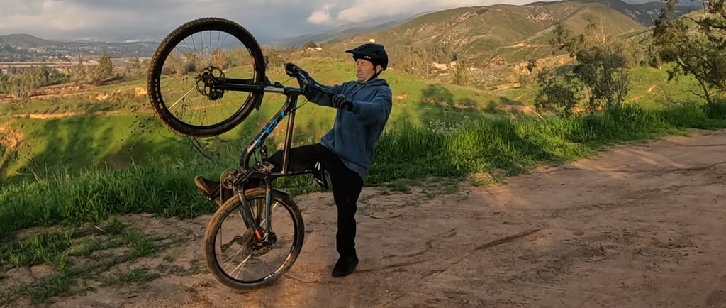 mountain biker stepping off back of bike after loopout on wheelie
