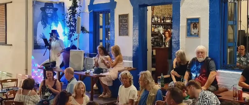 a group of people sitting at tables outside