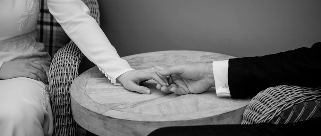 Black and White wedding photo of bride and groom holding hands