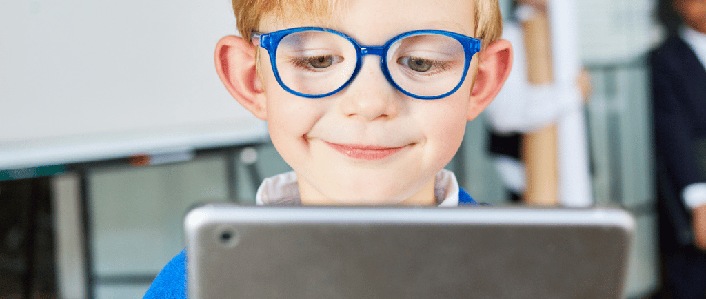 menino crianca de cabelos loiros e oculos azuis vendo celular
