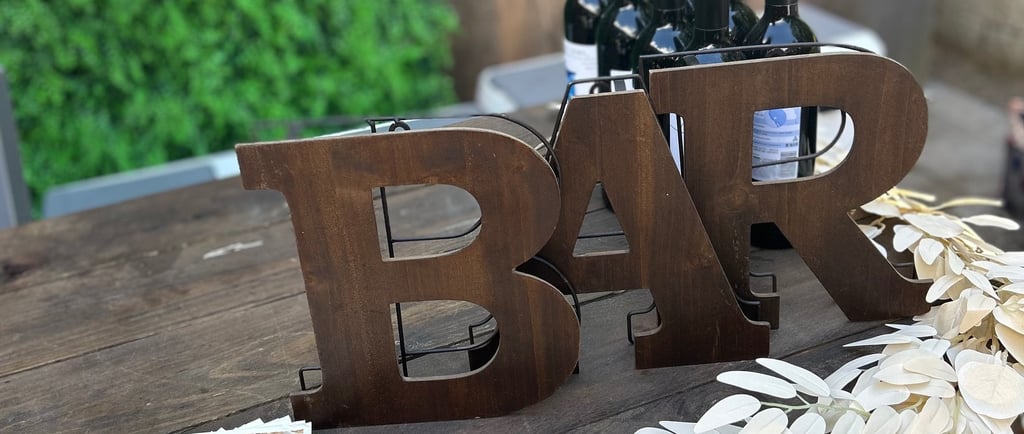 wine bottles with a wooden bar sign