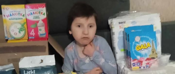 дівчинка сидить на дивані з великою кількістю підгузників