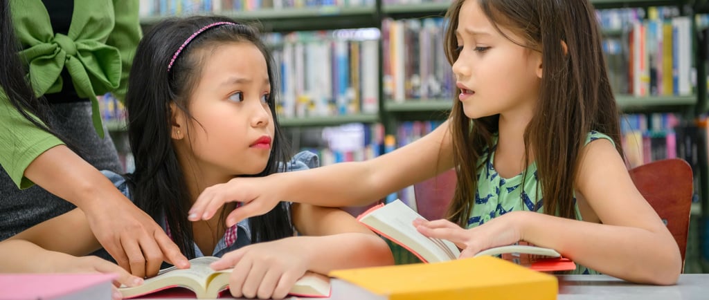 Enfant timide lisant seul un livre personnalisé dans une bibliothèque
