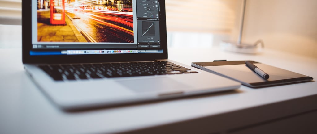 open laptop sitting on a white desk with the laptop screen showing sped up traffic and light