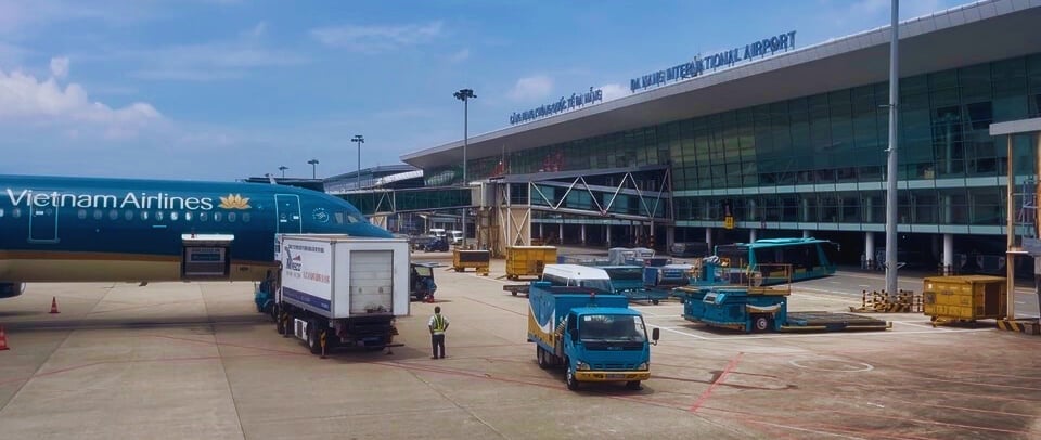 Vietnam Airlines plane at Da Nang International Airport with ground crew servicing the aircraft