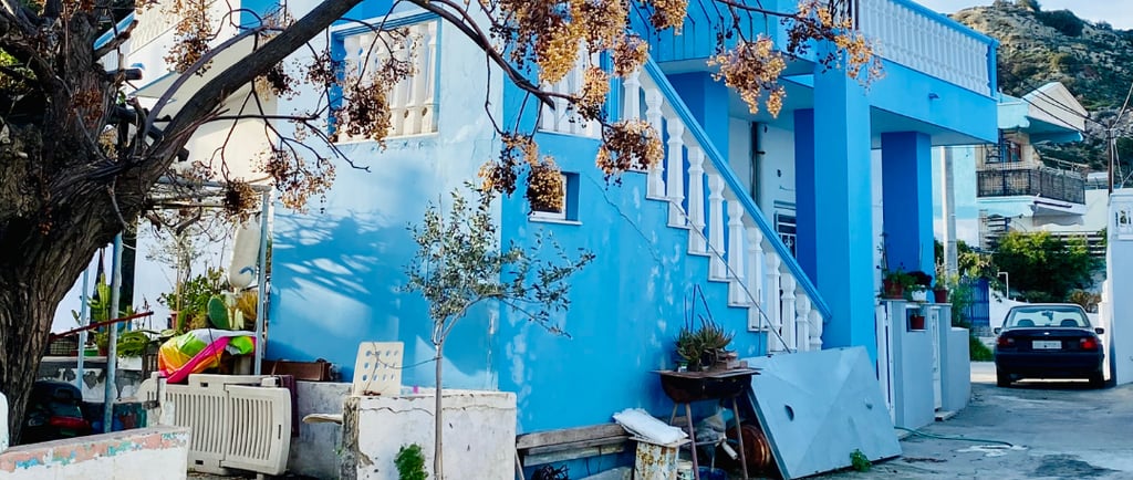 a blue house with a tree in the foreground