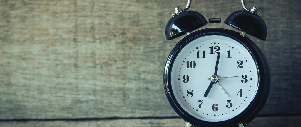 Alarm clock in front of wooden wall
