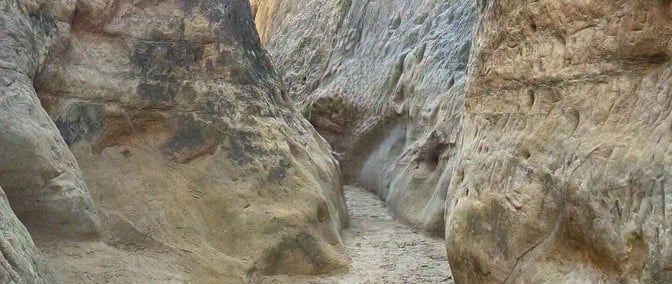 a narrow section of Annie's Canyon Trail. tall, steep rocks on either side of the trail.