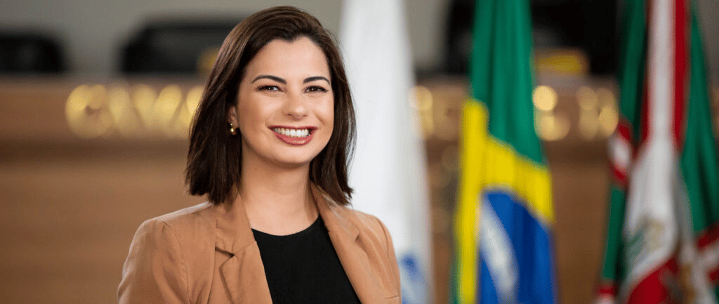 Amália Tortato mulher branca de cabelos castanho usando jaqueta marrom