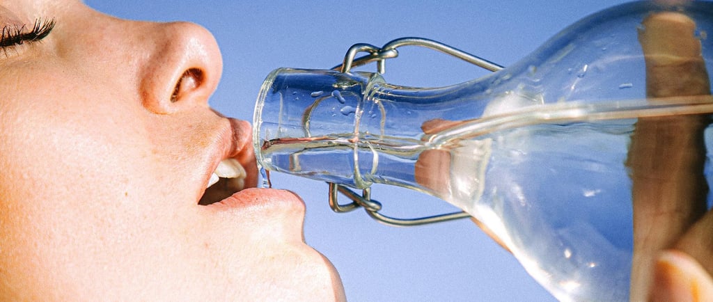 a woman drinking from a bottle of water