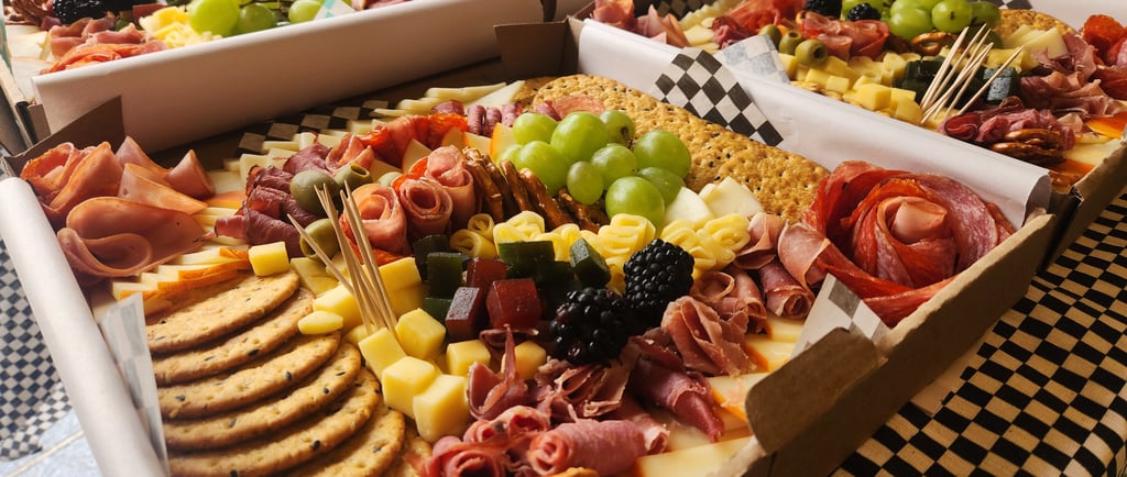 a variety of food, cheese, fruit and crackers in boxes