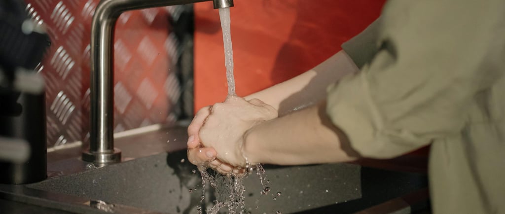 grifo de agua y manos de una persona que se lava