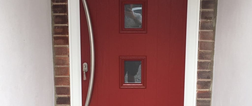 a new red composite front door with 4 squares of glass and curved long handle