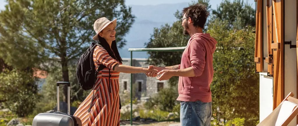 Host welcoming a guest at a vacation rental, enhancing Airbnb and VRBO listings