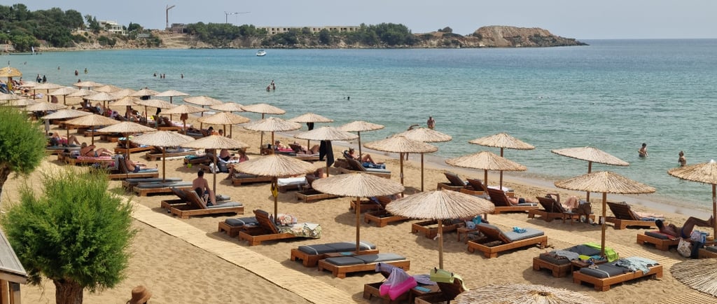 a beach with many lounge chairs and umbrellas