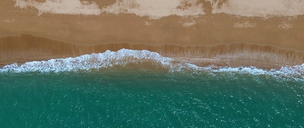 Playa de arena y agua cristalina vista desde arriba