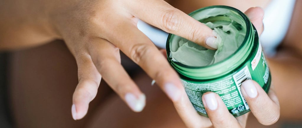 a woman holding a jar of cream in her hand
