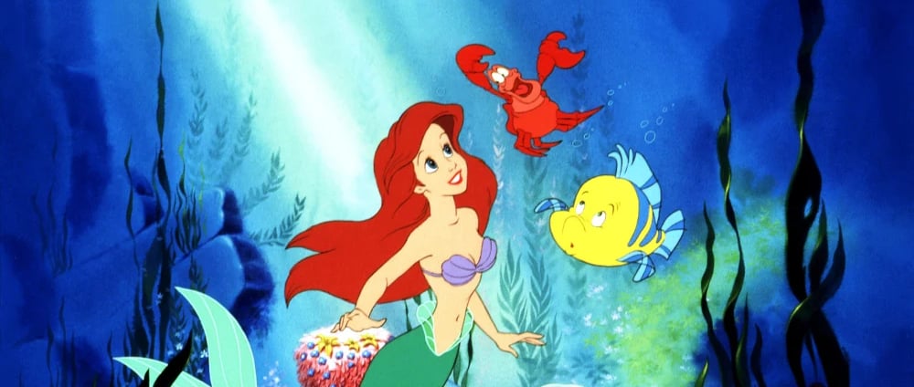 Ariel swims underwater with sea creatures in Disney’s The Little Mermaid (1989)