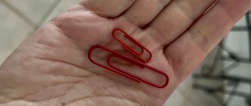 two red paper clips held in hand