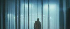 a person walking through woods illuminated by eerie lights