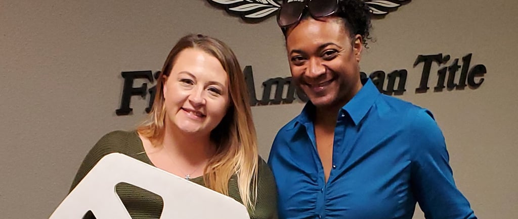 two women standing next to each other holding a sign