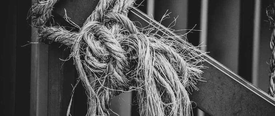 aggrippement, dépendance au travail, un noeud de corde autour d'une structure métallique