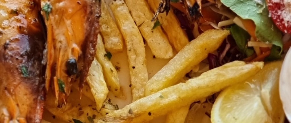 a plate of food with shrimp and fries